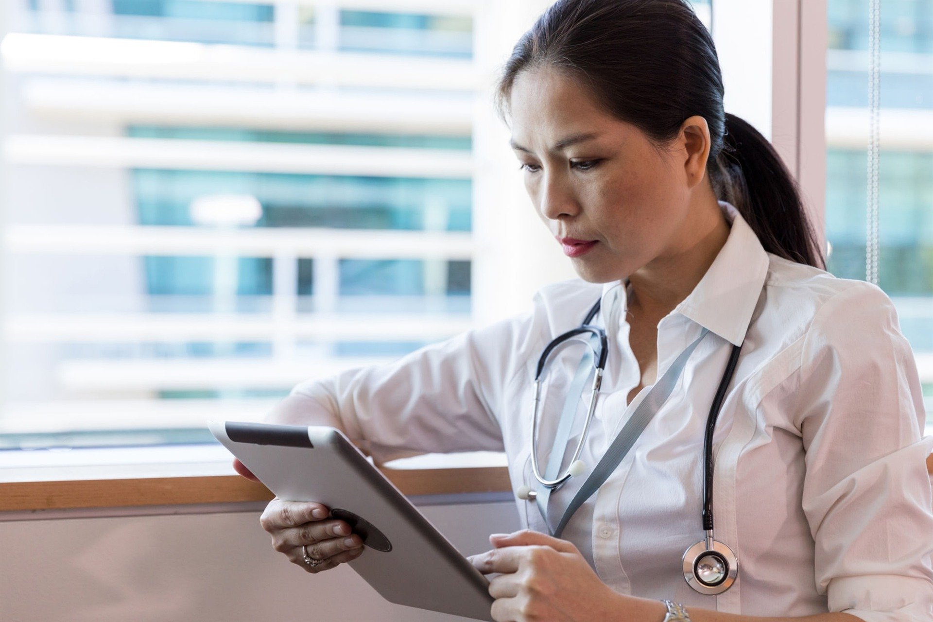 doctor looking at medical notes on a tablet