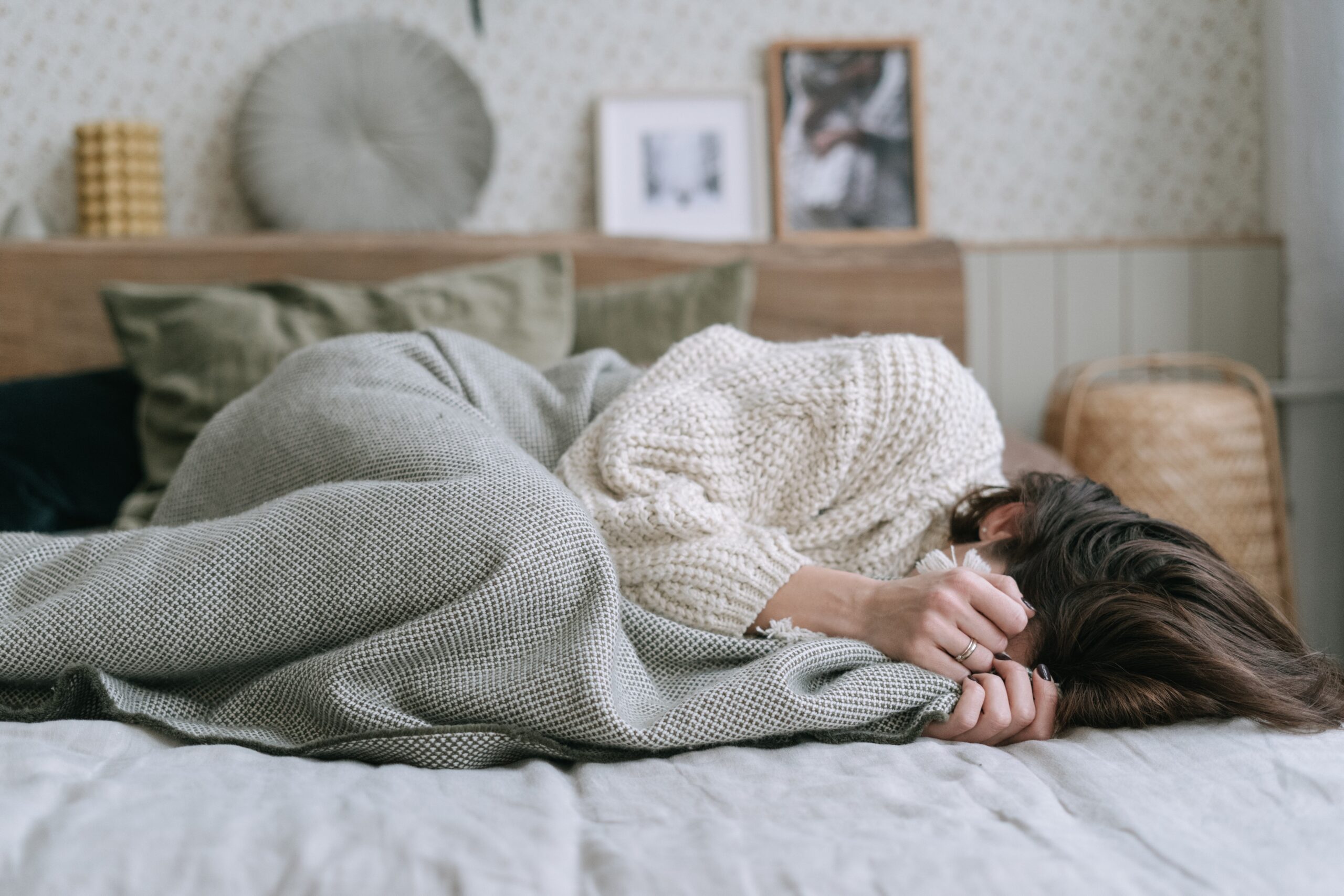 woman lying down on a bed with her face covered